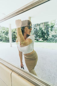 Young woman seen through glass