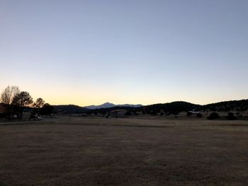 Scenic view of field against clear sky during sunset