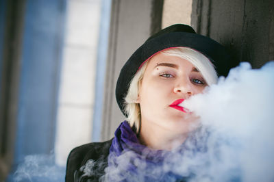 Close-up portrait of woman smoking in city