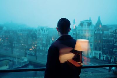 Rear view of man looking at city buildings