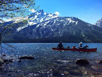 People on boat against mountains and sky