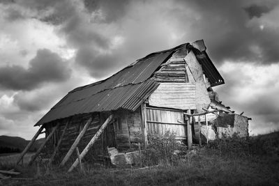 Abandoned house on field against sky