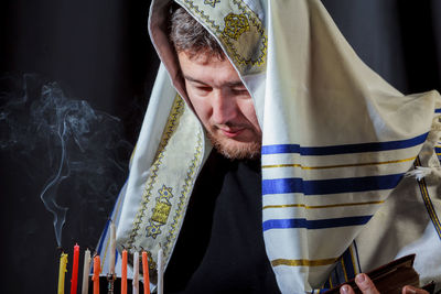 Man looking at candles on menorah