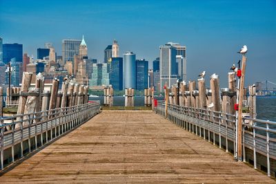 View of pier by sea against buildings in city