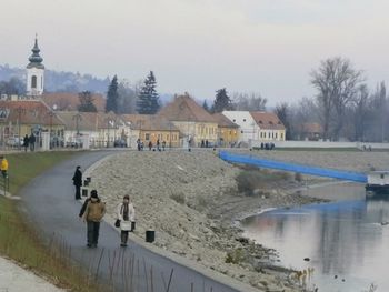 People on shore against sky