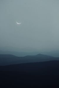 Scenic view of silhouette mountains against sky at night