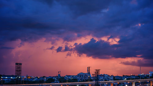 Illuminated buildings against sky during sunset