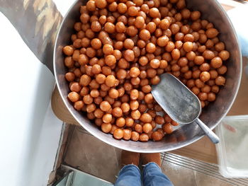 Low section of person by sweet food in container