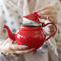 Close-up of hand holding teapot