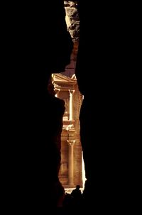 Low angle view of silhouette sculpture against building