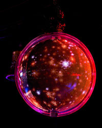 Close-up of illuminated lamp over black background
