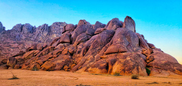 Rock formations against clear blue sky