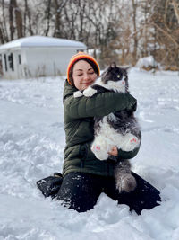 Portrait of young woman skiing on snow covered field