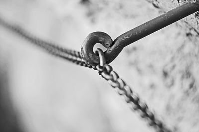 Close-up of chain and rope tied to metal fence