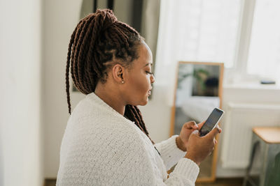 Side view of young man using mobile phone