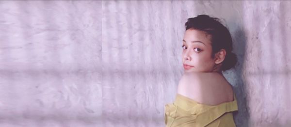 Portrait of girl standing against wall