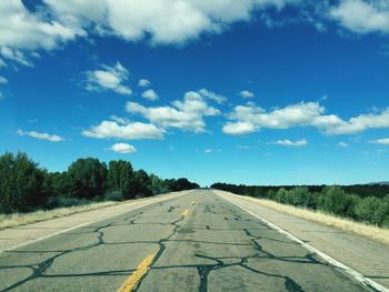 Road by landscape against blue sky