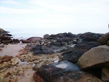 Rocks on beach against sky