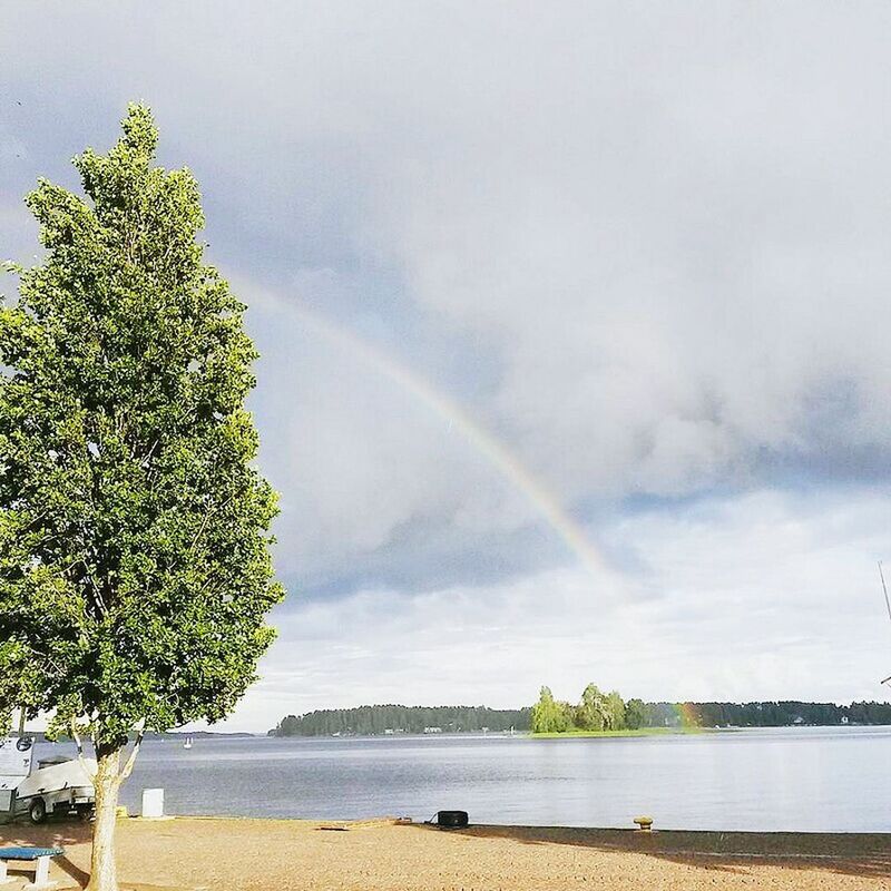 SCENIC VIEW OF RAINBOW OVER RIVER AND TREES AGAINST SKY