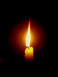 Close-up of lit candle in dark room