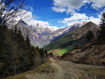 Road amidst snowcapped mountains against sky