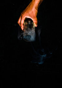 Close-up of human hand against black background