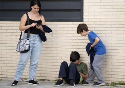 Family of mother and two kids addicted and obsessed with modern gadgets in the street