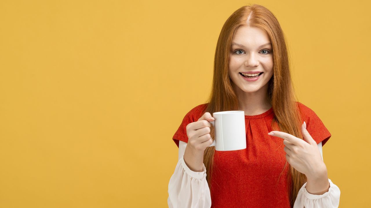 PORTRAIT OF YOUNG WOMAN DRINKING COFFEE