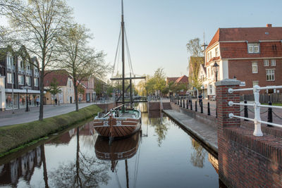 Canal amidst buildings in city against sky