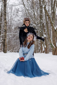 Portrait of young woman standing in snow