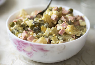 Close-up of olivier salad in bowl on table at home