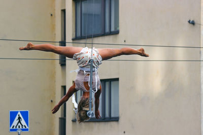 Midsection of man with arms raised against wall