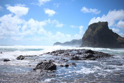 Scenic view of rocks in sea against sky