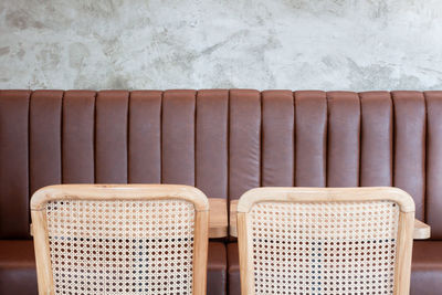 Close-up of empty seats on table against wall