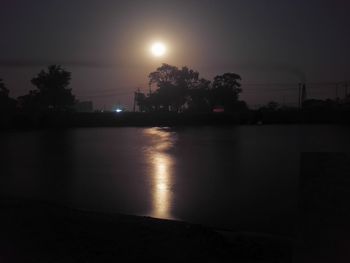 Scenic view of lake against sky at night