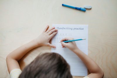 High angle view of girl drawing on paper