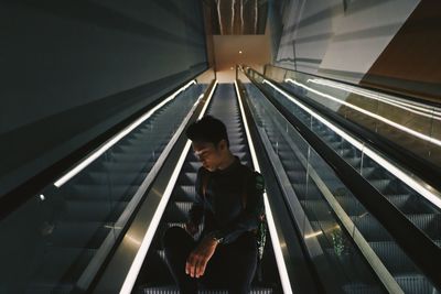Low angle view of boy standing on escalator