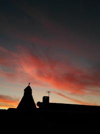 Silhouette statue against sky at sunset