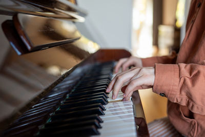 Midsection of woman playing piano