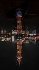 Illuminated building in city against sky at night