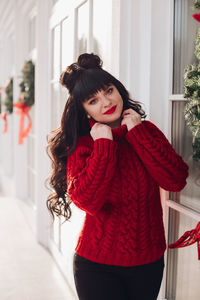 Portrait of a young woman in a warm knitted red sweater outside