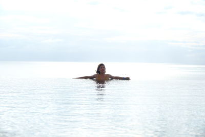 Man in swimming pool in sea against sky