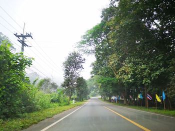 Road amidst trees against sky