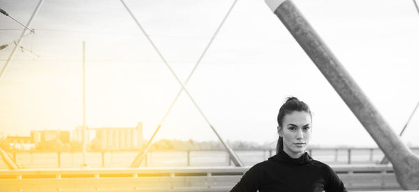 Portrait of young woman standing against sky