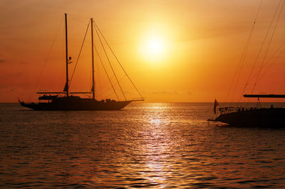 Silhouette sailboats on sea against sky during sunset