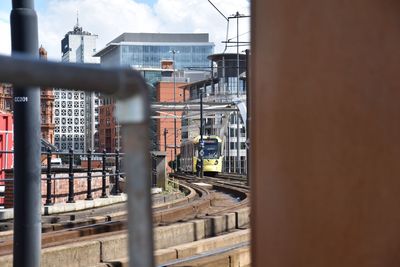 Train on railroad tracks in city against sky