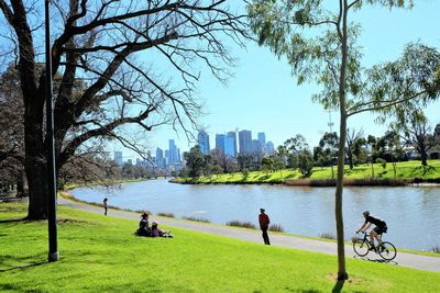 People in park by city against sky