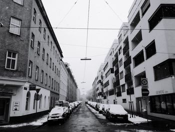 Cars on city street against sky