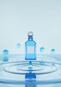 Close-up of water drop on glass against white background