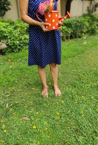 Low section of woman standing on field